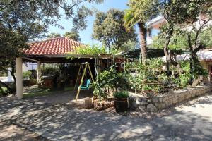 ogród z huśtawką i roślinami w obiekcie Apartments Karas on the island of Pag w mieście Mandre
