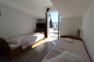sypialnia z dwoma łóżkami i balkonem w obiekcie Apartments Karas on the island of Pag w mieście Mandre