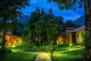 a resort yard at night with trees and lights at Pousada Opicodocipo in Santana do Riacho