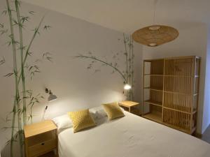 - une chambre avec un lit blanc et une plante sur le mur dans l'établissement Vivienda vacacional sur de europa b 3 4, à La Restinga
