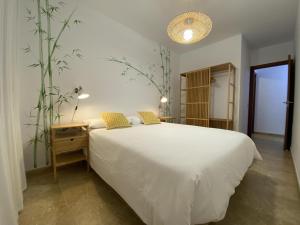 Un dormitorio con una gran cama blanca y una planta en Vivienda vacacional sur de europa b 3 4 en La Restinga