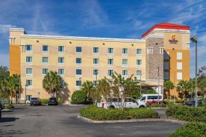 an exterior view of a hotel with a parking lot at Comfort Suites At Fairgrounds-Casino in Tampa
