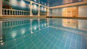 ein Pool mit blauem Wasser in einem Gebäude in der Unterkunft Moselstern Hotel Brixiade &Triton in Cochem