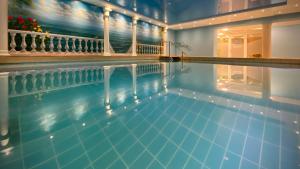 ein Swimmingpool mit blauem Wasser in einem Gebäude in der Unterkunft Moselstern Hotel Brixiade &Triton in Cochem