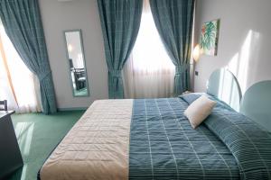 a bedroom with a large bed and a window at Hotel Vittoria in Sondrio