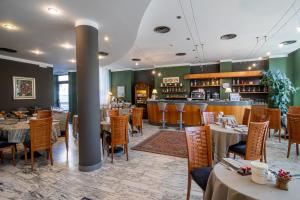 ソンドリオにあるHotel Vittoriaのテーブルと椅子のあるレストラン、バー