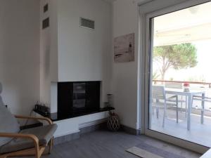 een woonkamer met een open haard en een glazen schuifdeur bij Breezy summer maisonette with exciting view! in Aghia Marina