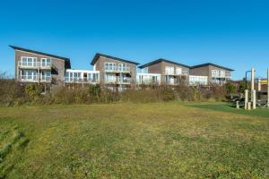 eine Reihe von Häusern auf einem Hügel mit einem Grasfeld in der Unterkunft Standleven appartement 106 - Groote Keeten in Callantsoog
