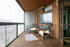 a balcony with two chairs and a table and windows at 2ndhomes Apartment in Kamppi Center with Sauna and Balcony in Helsinki