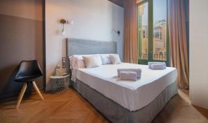 a bedroom with a bed with white sheets and a window at You Stylish Paseo de Gracia Apartments in Barcelona