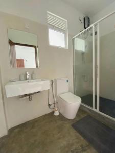 ein Badezimmer mit Toilette, Waschbecken und Dusche in der Unterkunft Kalan Mirissa in Mirissa