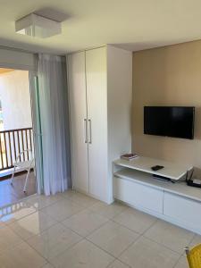 a living room with a flat screen tv on a wall at Flat no Club Meridional de Carneiros - Bloco 4-2PP in Tamandaré