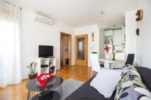 ザグレブにあるApartman Retroのソファとテーブルのあるリビングルーム