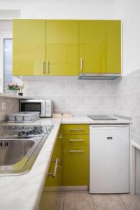 a kitchen with yellow cabinets and a sink at Anima Mea Apartment in Dubrovnik