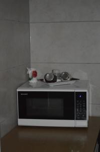 a microwave with two pots and pans on top of it at Noclegi nad lasem in Gliczarów
