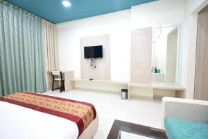 Habitación de hotel con cama y TV en The Sky Imperial- Hotel Gopal Darshan, en Nathdwara