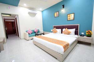 ein Schlafzimmer mit einem großen Bett und einer blauen Wand in der Unterkunft The Sky Imperial- Hotel Gopal Darshan in Nāthdwāra