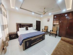 1 dormitorio con 1 cama, mesa y sillas en Hotel White Pearl, en Lahore