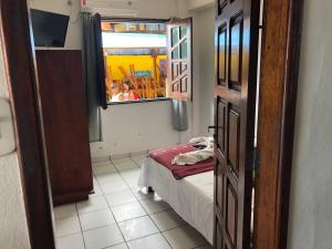 a room with a bed and a window with people at Pousada Tranquila in Morro de São Paulo