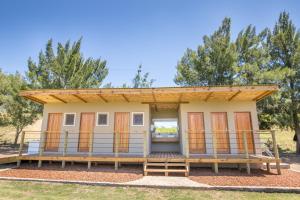 a tiny house with a large deck at Glen Eden Farm in Boesmanspad