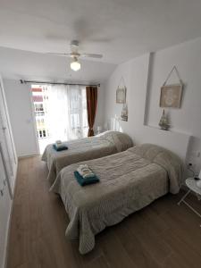a bedroom with two beds and a window at Villa Megila in Caleta De Fuste +40 photos