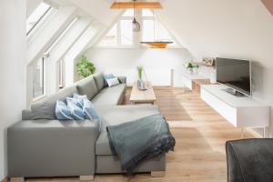 a living room with a couch and a tv at Winkelschiffchen IV mit Sauna in Juist