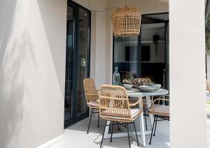 a dining room with rattan chairs and a table at Ibiza style bungalows with sea views in Balzi Rossi in Ventimiglia
