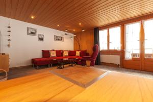 a living room with a red couch and a table at Chalet Schwendiboden in Grindelwald