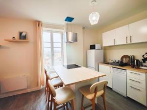 a kitchen with a table and chairs and a counter top at T2 neuf Le SCANDINAVE in Riom