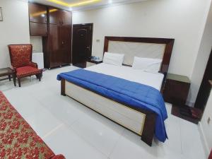 Hotel White Pearl في لاهور: غرفة نوم عليها سرير وبطانية زرقاء