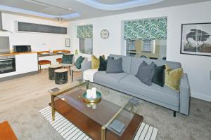 ein Wohnzimmer mit einem Sofa und einem Tisch in der Unterkunft Antrobus Deluxe Apartments by YourStays in Congleton