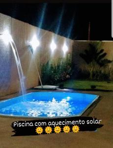a swimming pool with a water fountain in a backyard at Casa Temporada Nosso Recanto Piscina aquecimento Solar in Olímpia