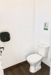 uma casa de banho com um WC branco e um dispensador de papel em FamilyCamp hospedagem perto do Magic City em Suzano