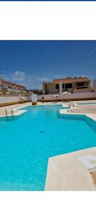a large pool with blue water in front of a building at Villa Megila in Caleta De Fuste