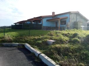 una casa con un campo de hierba delante de ella en Apartamentos Rurales Miramar, en Pimiango