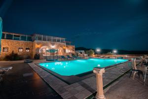a swimming pool at night in front of a building at Melies Hotel in Kokkinórrakhi