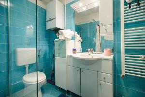 ザグレブにあるApartman Retroの青いタイル張りのバスルーム(トイレ、シンク付) +11枚の写真