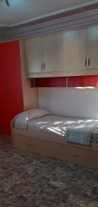 ein Schlafzimmer mit einem Bett mit Schränken darüber in der Unterkunft CASA SARA (SARA'S HOUSE) in Güímar