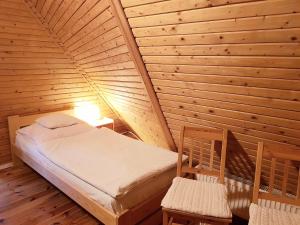 a bedroom with a bed and two chairs in a room at Willa Góralka in Karpacz