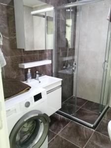 a bathroom with a washing machine and a shower at Siberland olive garden 1+1 residence spa - pool in Alanya