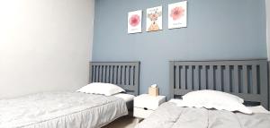 2 camas en un dormitorio con paredes azules en Healinghouse Peakjang, en Buyeo
