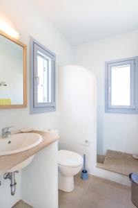 a white bathroom with a toilet and a sink at Serifos Stone Villa B in Rámos