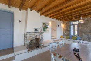 a living room with a fireplace and a table and chairs at Serifos Stone Villa B in Rámos
