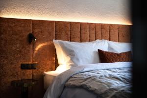 una camera da letto con letto, lenzuola e cuscini bianchi di Apart Sailers a Sankt Anton am Arlberg
