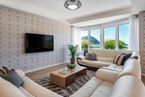 a living room with two white couches and a tv at La Concha Beach Deluxe in San Sebasti&aacute;n