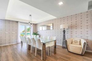 a dining room with a glass table and white chairs at La Concha Beach Deluxe in San Sebasti&aacute;n