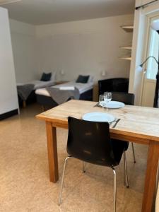 uma mesa de madeira com 2 cadeiras e uma sala de estar em Volontärgatan - Visby Lägenhetshotell em Visby