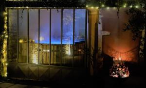 a window with a view of a building with lights at La petite madeleine - Chambre d'hôtes & spa in Burgy