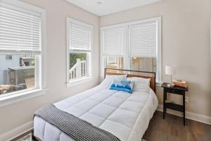 a white bedroom with a large bed and windows at Renovated Beach Block 7BR North Beach Atlantic City - Steps to Beach & Casino in Atlantic City