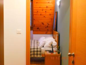 a small bedroom with a bed and a wooden headboard at Aparthotel Vučko Apartment Lora in Jahorina